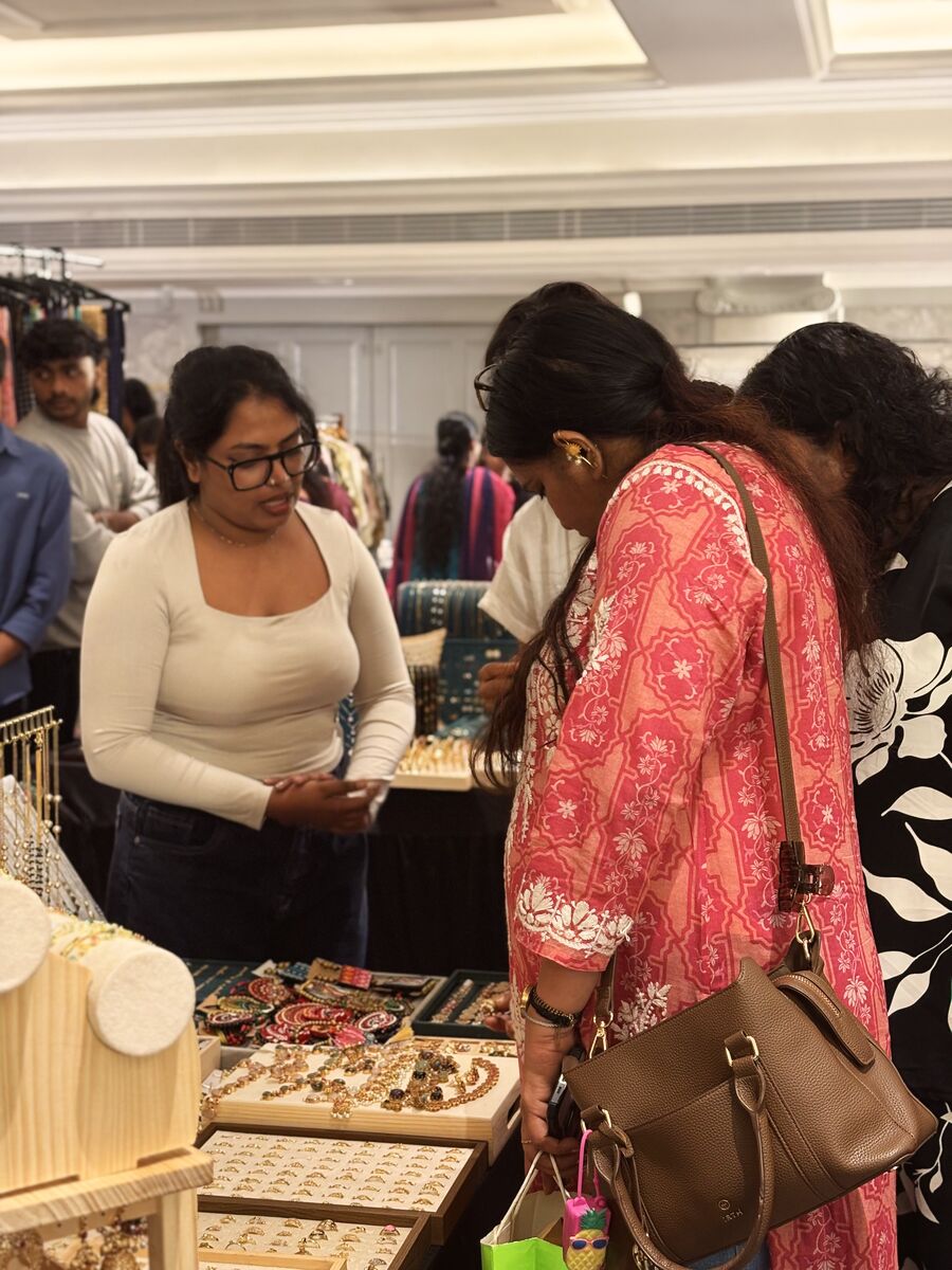 Two visitors browsing a jewellery stall